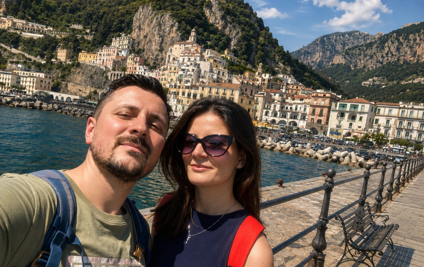 Coppia sul lungomare di Amalfi con vista sulla Costiera Amalfitana durante un viaggio senza auto